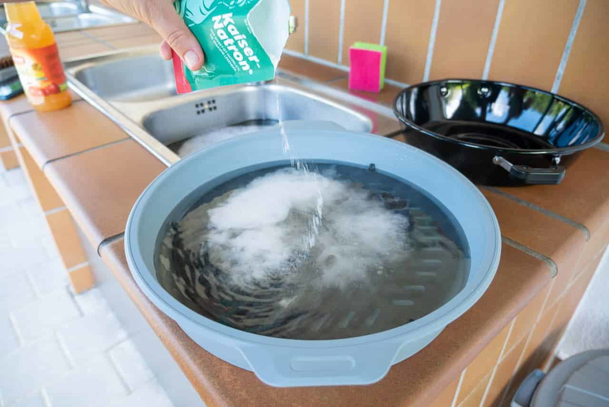 Vuil grillrooster schoonmaken met soda en azijn.